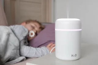 A baby sleeping beside a humidifier